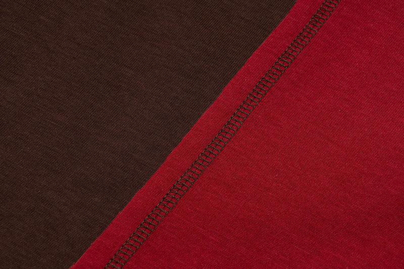 Close-up of a red and brown vintage sports tee with diagonal contrast stitching and textured fabric detail