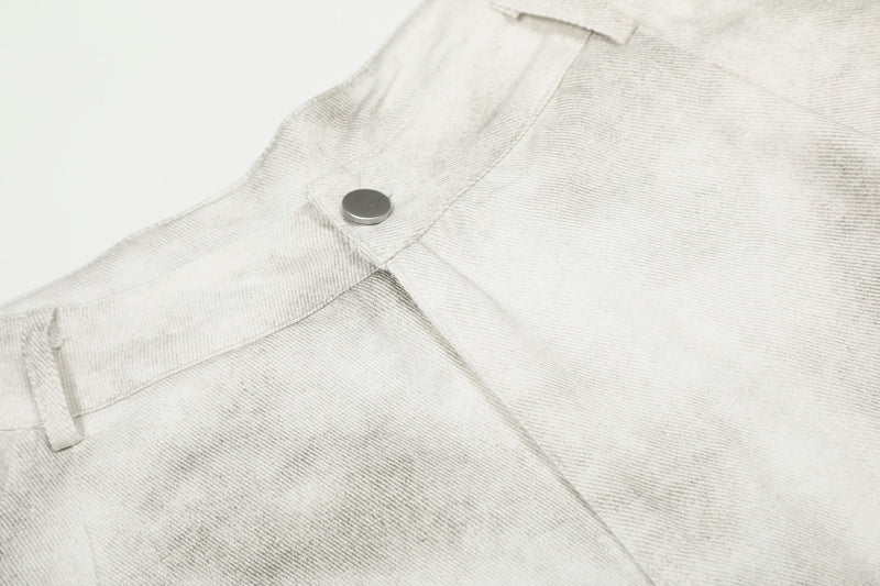 Close-up of the waistband snap button and seam details on white washed cargo pants
