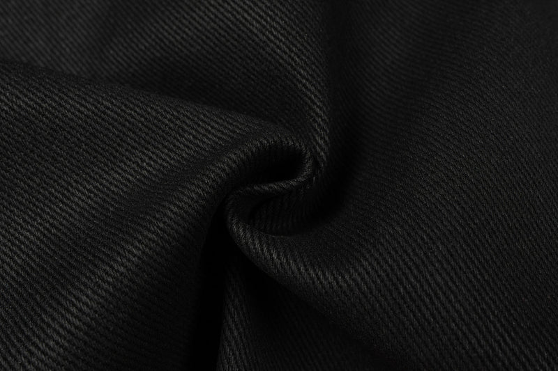 Extreme close-up of black denim fabric texture and fold detail