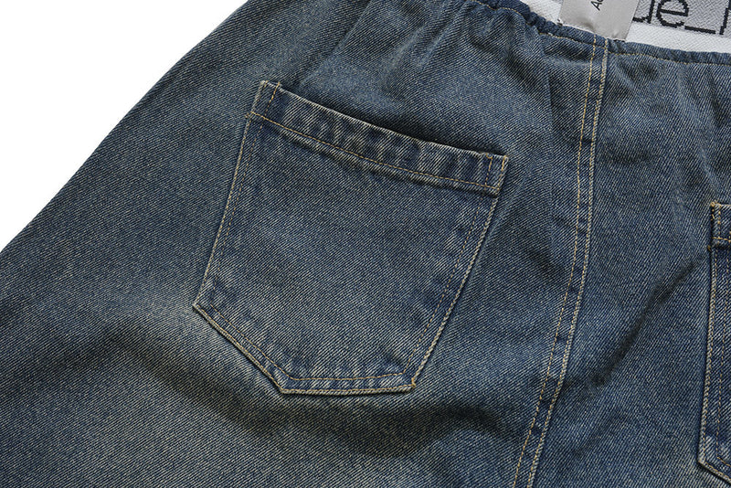 Close-up of back patch pocket on dark wash denim pants