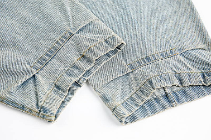 Close-up of lower leg hems on washed light blue barrel leg jeans