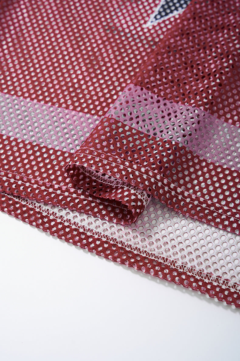 Close-up of red mesh jersey fabric with white stripe and stitched hem, showing retro varsity shirt texture