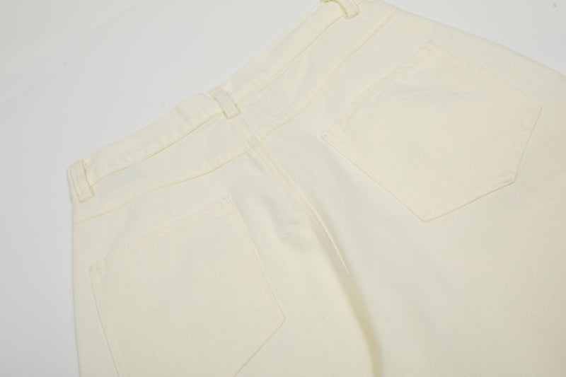 Close-up of cream cargo pants back pocket and waistband seam detail