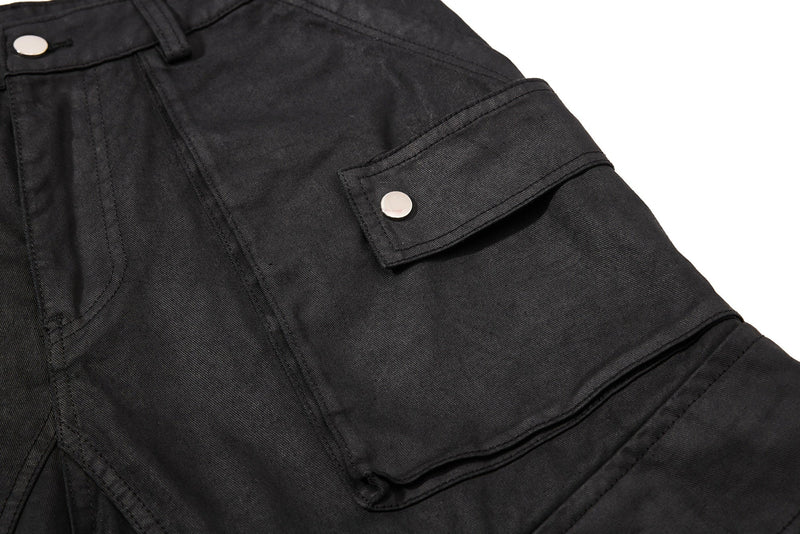 Close-up of black cargo shorts side flap pocket with silver snap button