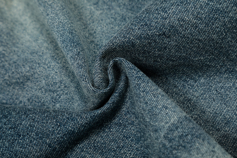 Close-up of blue denim fabric swirl showing woven texture and wash variation