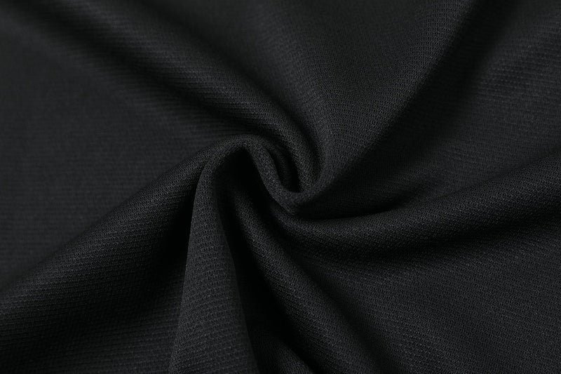 Matte black textured tech fabric with soft folds and a sleek oversized streetwear look
