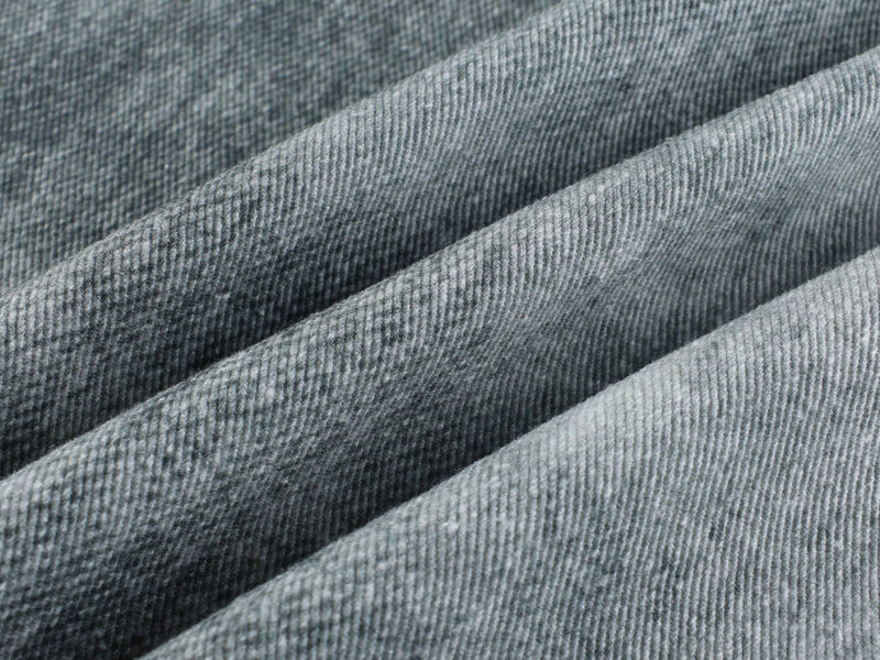 Close-up of faded denim fabric texture with soft diagonal folds
