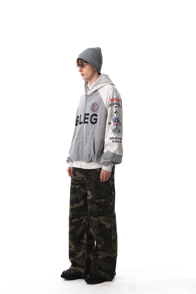 Model wearing gray and white BLEG zip-up hoodie with distressed graphics, side view