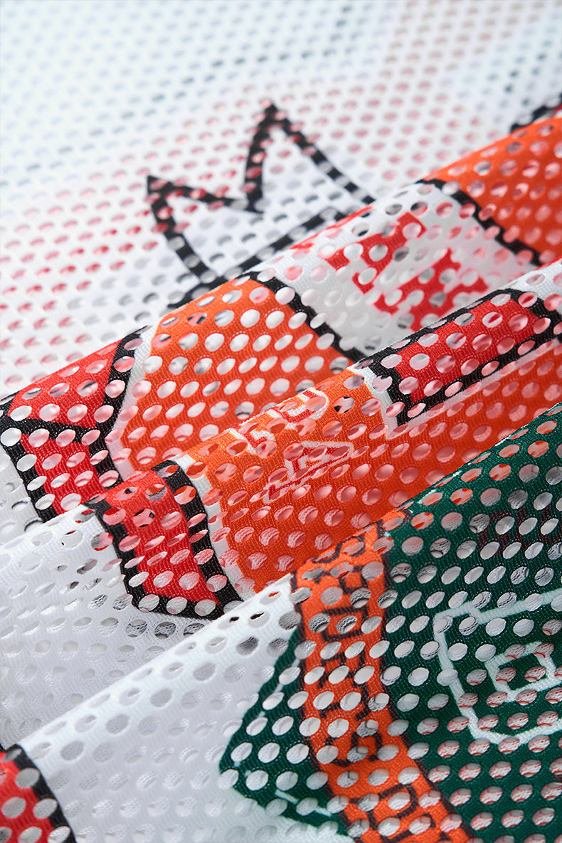 Close-up of Seakoff Legend 88 mesh jersey fabric with perforated red, orange, green, and white varsity-style detailing