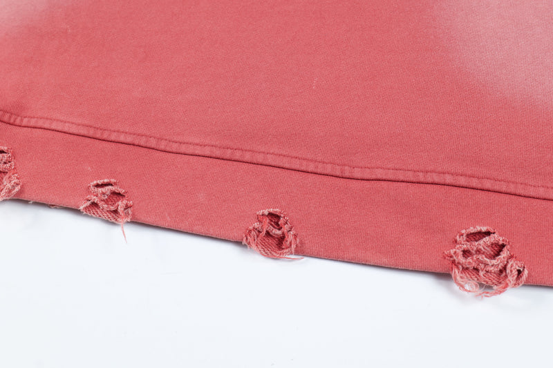 Close-up of red hoodie hem with ripped distressing along the bottom edge