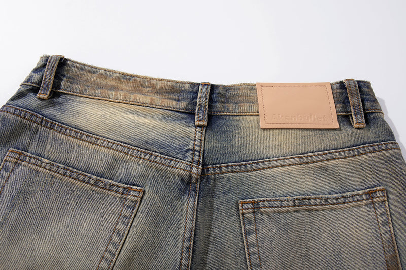 Back waistband close-up with leather label, belt loops, and faded wash