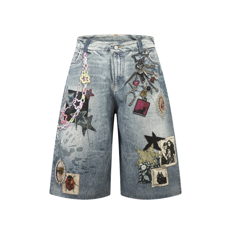 Front view of light wash denim shorts with layered patchwork, hanging charms, and wide legs