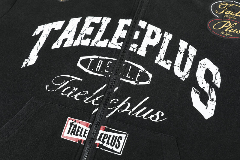 Front close-up of distressed white logo print on black zip-up hoodie