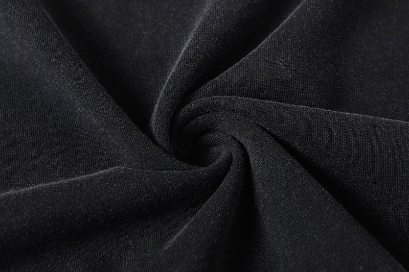 Close-up of black tee fabric with soft knit texture and folds