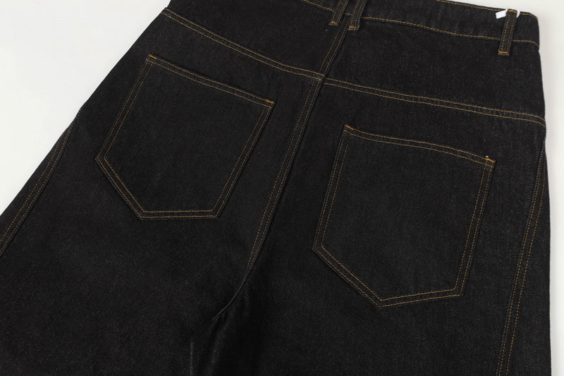 Back view close-up of black denim pants with patch pockets and topstitched seams