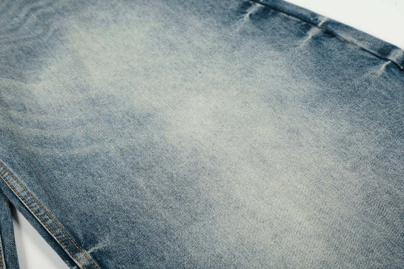 Close-up of faded blue denim fabric with soft wash and visible twill texture