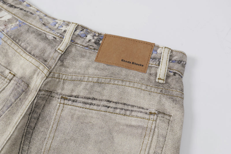 Close-up of back waistband label and pocket stitching on washed botanical print jeans