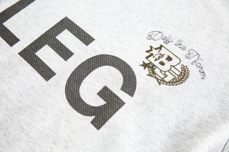 Close-up of BLEG chest print and crest graphic on off-white tee