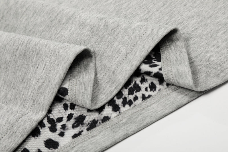 Close-up of a light gray quarter-zip polo shirt with leopard print trim and soft cotton fabric details