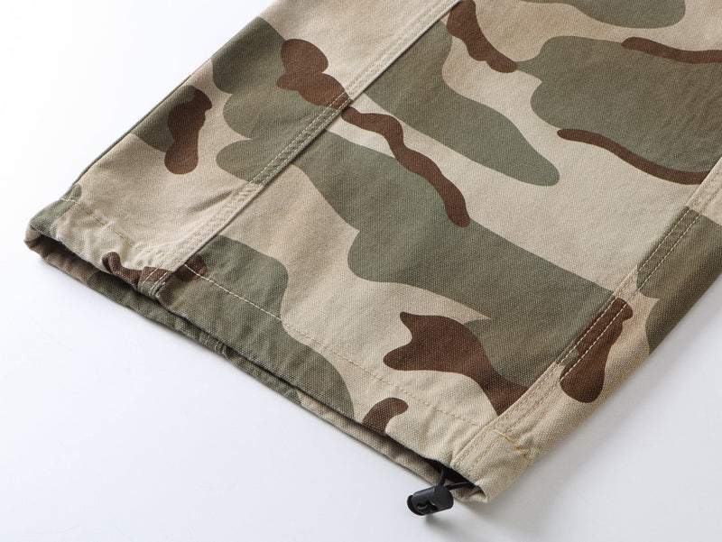 Lower hem of camouflage pants with drawcord detail and camouflage pattern