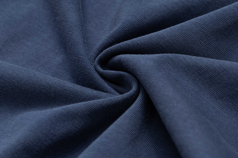 Close-up of navy blue cotton fabric with soft folds, showing the texture of an oversized vintage graphic tee