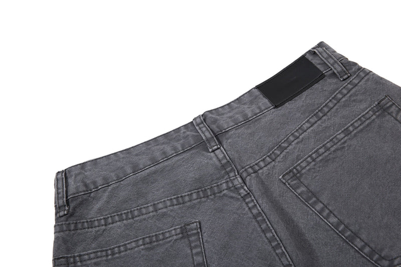 Close-up of charcoal denim back waistband and patch detail