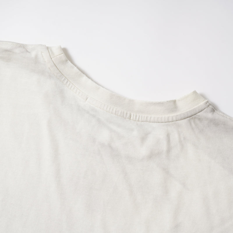 Close-up of cream ribbed crewneck collar and shoulder seam on a long sleeve tee