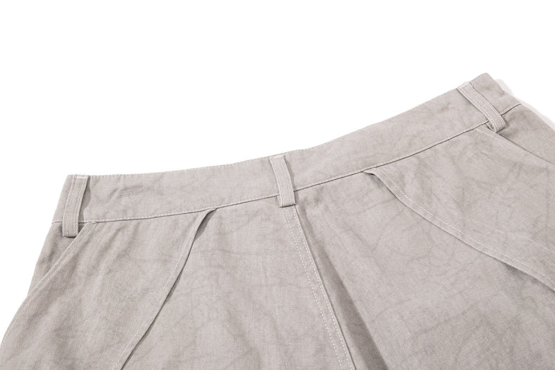 Light beige denim back waist close-up with belt loops and pleat seam detail