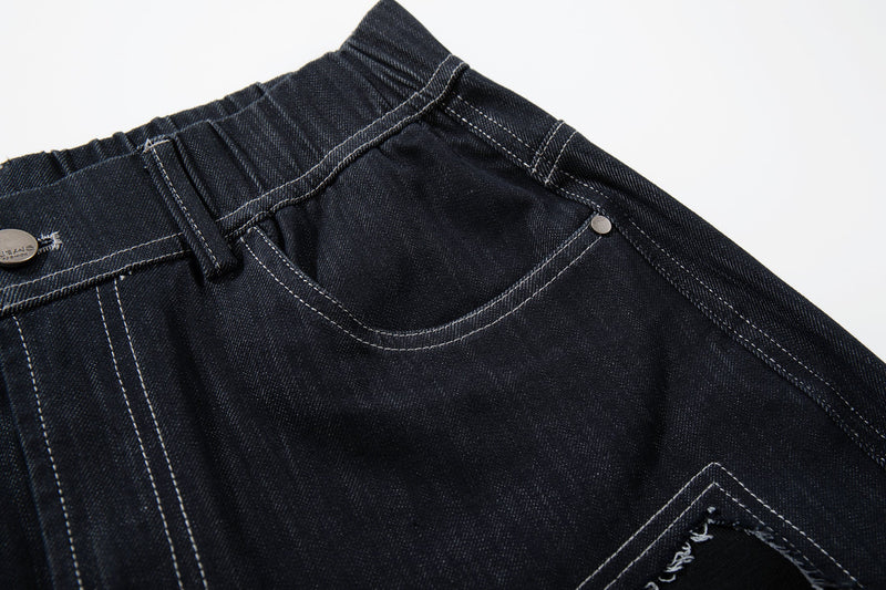 Close-up of the front right pocket and waistband on dark denim jeans with curved stitching
