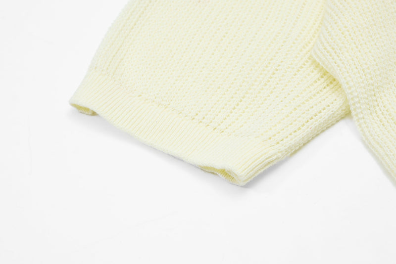 Cream knit varsity polo sleeve cuff with textured waffle weave and ribbed hem on a white background