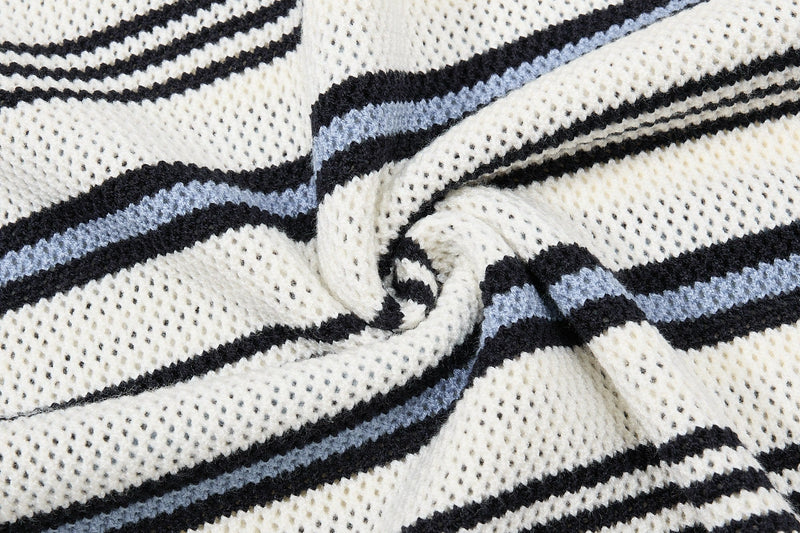 Close-up of cream knit polo fabric with black and light blue retro collegiate stripes and textured weave