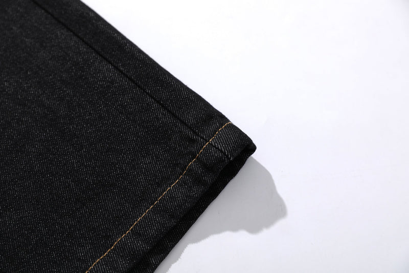 Close-up of black denim hem with contrast stitching