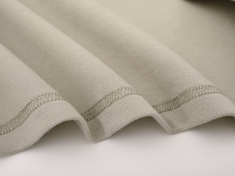 Close-up of beige sweatshirt hem with double-stitched finish