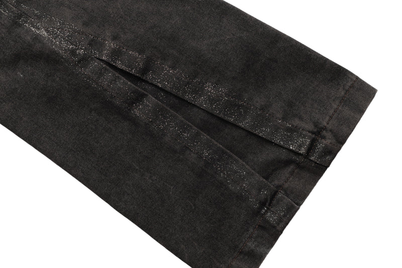 Close-up of dark brown jean leg with glitter-speckled seam and wide hem