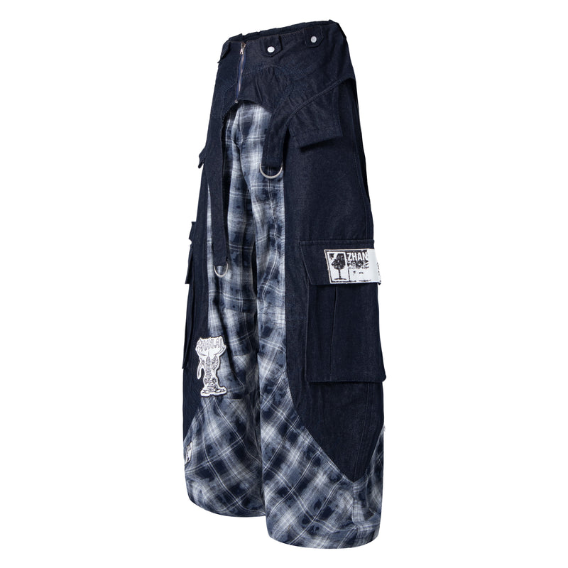 Side view of black cargo pants with gray plaid inset panels and white patch detail