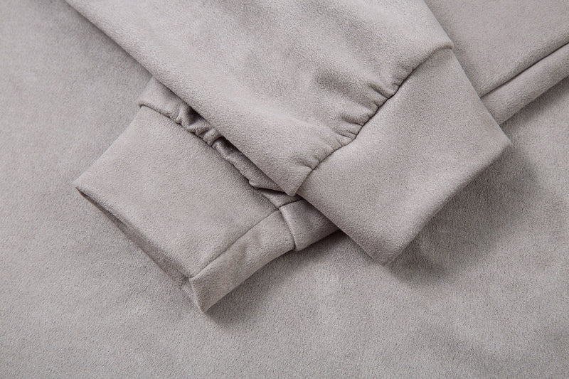 Close-up of sleeve cuff and seam details on the light gray long-sleeve polo shirt