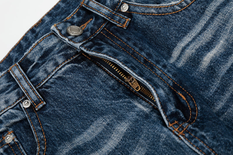 Close-up of the front fly and button on blue denim jeans with faded wash and metal zipper