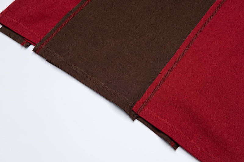 Close-up of a retro stripe tee with red and brown color blocks, visible seam stitching, and vintage sportswear texture