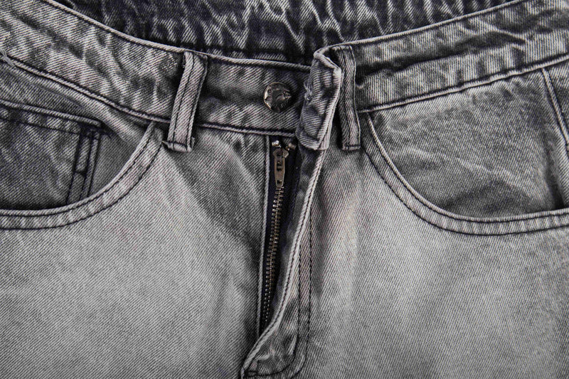 Close-up of the jeans front waistband with button fly and faded denim texture