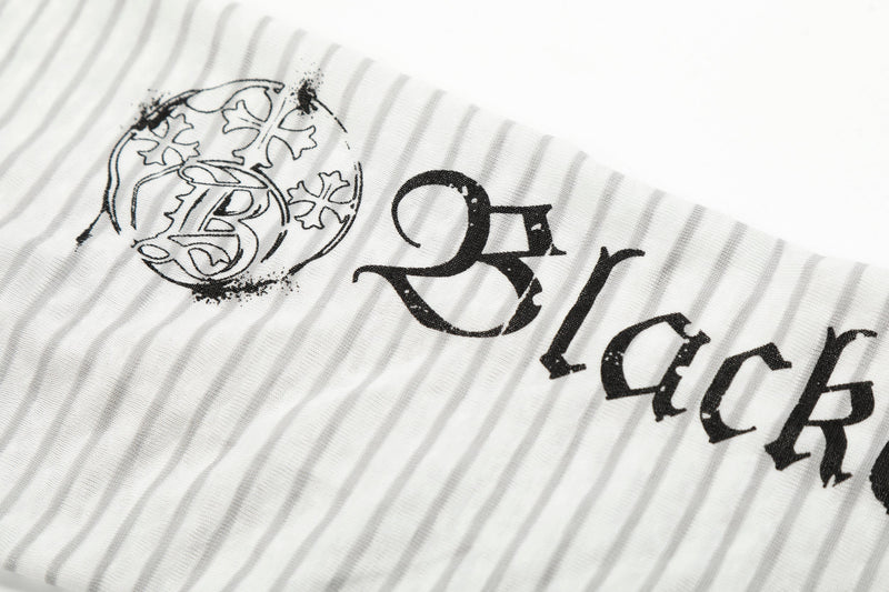 Close-up of black gothic lettering on white striped hoodie tee