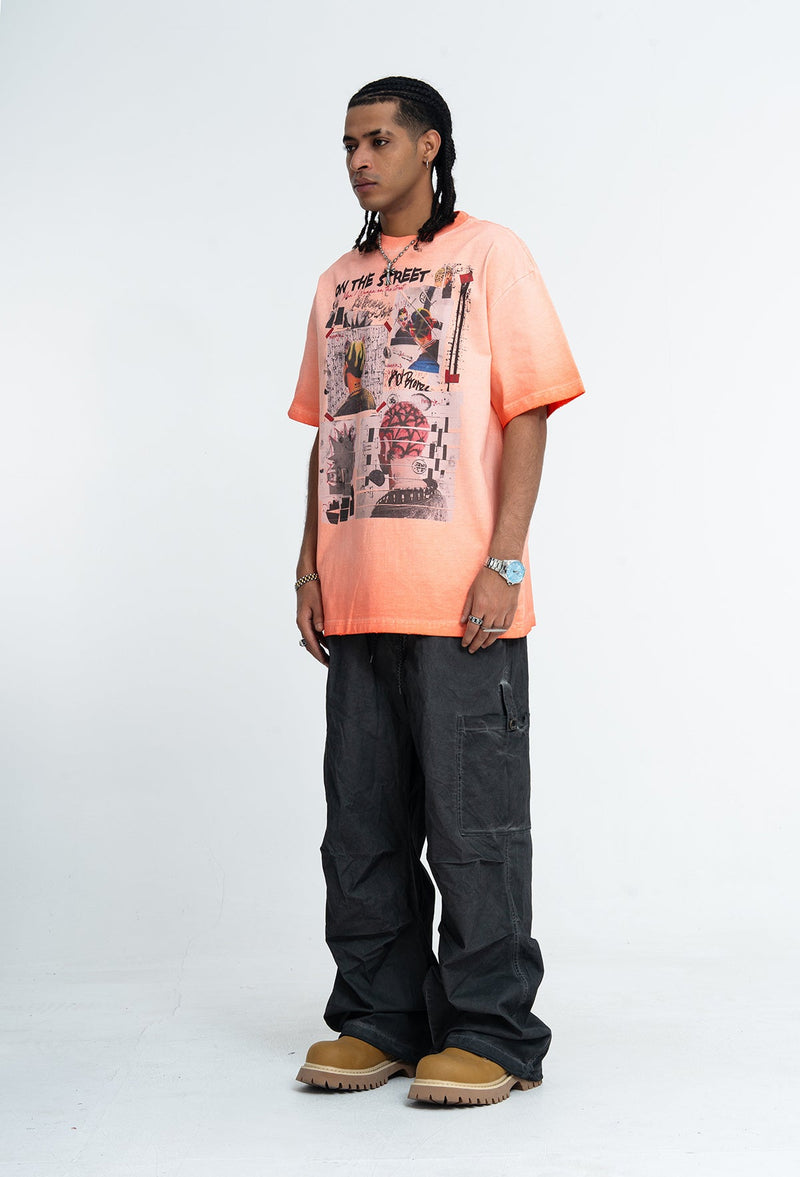 Model wearing a vintage wash peach graphic tee with collage print, black cargo pants, and tan boots on a white background