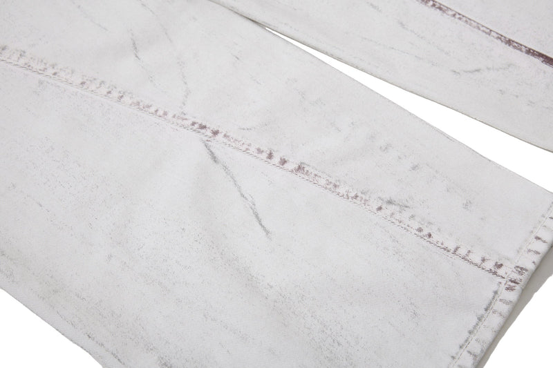 Close-up of lower leg fabric on white washed denim pants with panel seam