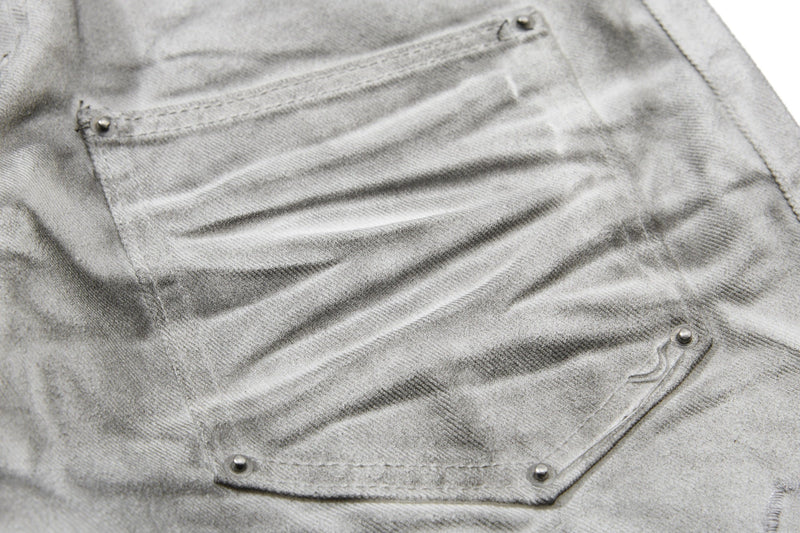 Close-up of light gray back pocket with rivets and washed finish