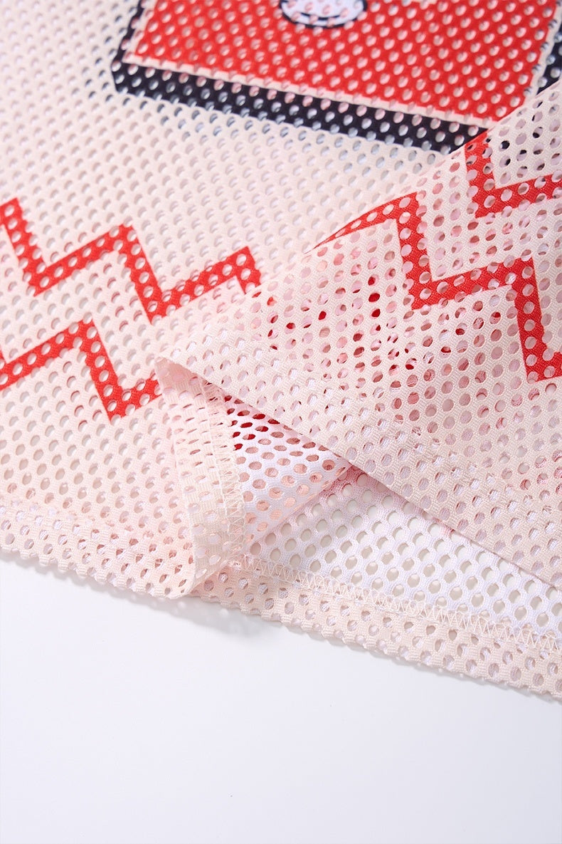Close-up of a red and white mesh jersey T-shirt with zigzag graphic details and stitched hem on streetwear fabric