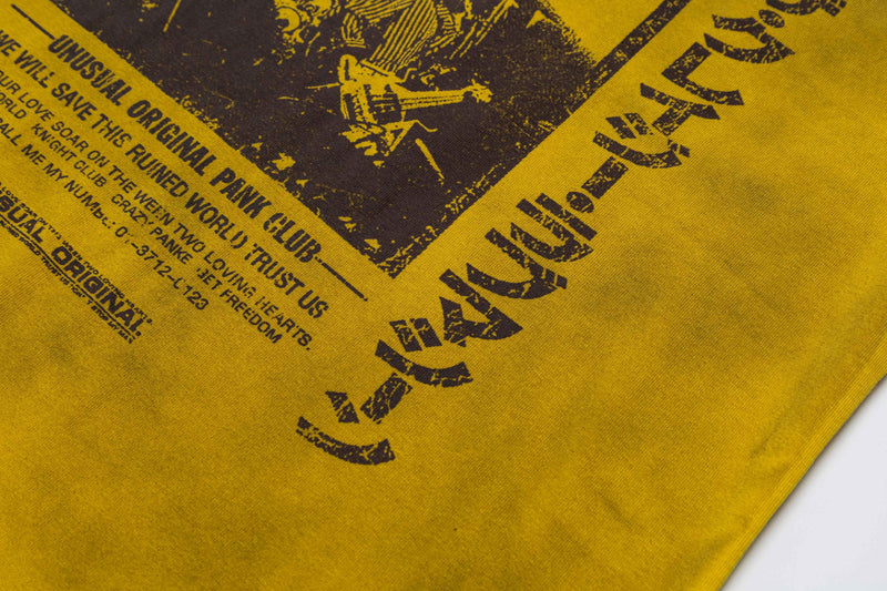 Mustard yellow washed graphic tee with distressed black punk-style print and bold retro text design