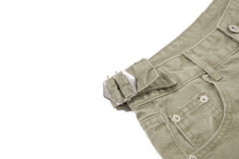 Close-up of olive green denim shorts side pocket and waistband buckle detail