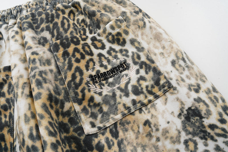 Close-up of back pocket with embroidered logo and star details on leopard print pants