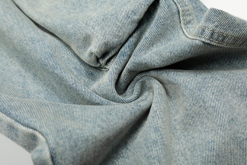 Light wash denim fabric close-up with folded texture