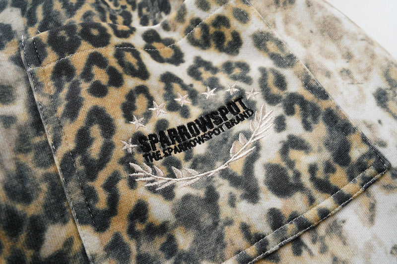 Close-up of back pocket with embroidered graphic on leopard print pants