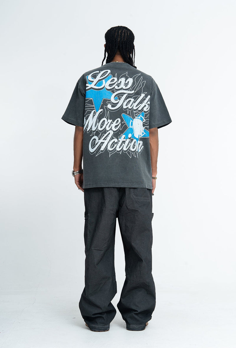Back view of a vintage washed charcoal graphic T-shirt with bold blue and white streetwear print reading Walk the Talk More Action